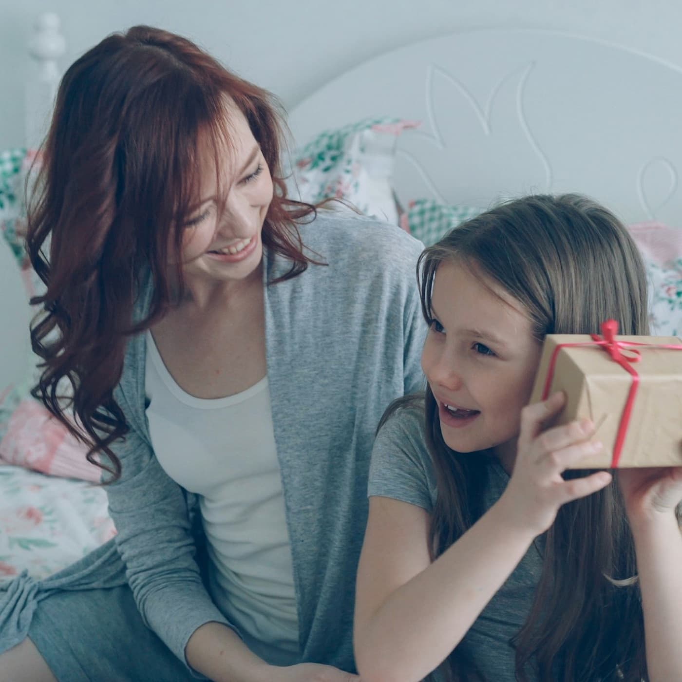 Eine Mutter überreicht ihrer Tochter ein eingepacktes Geschenk